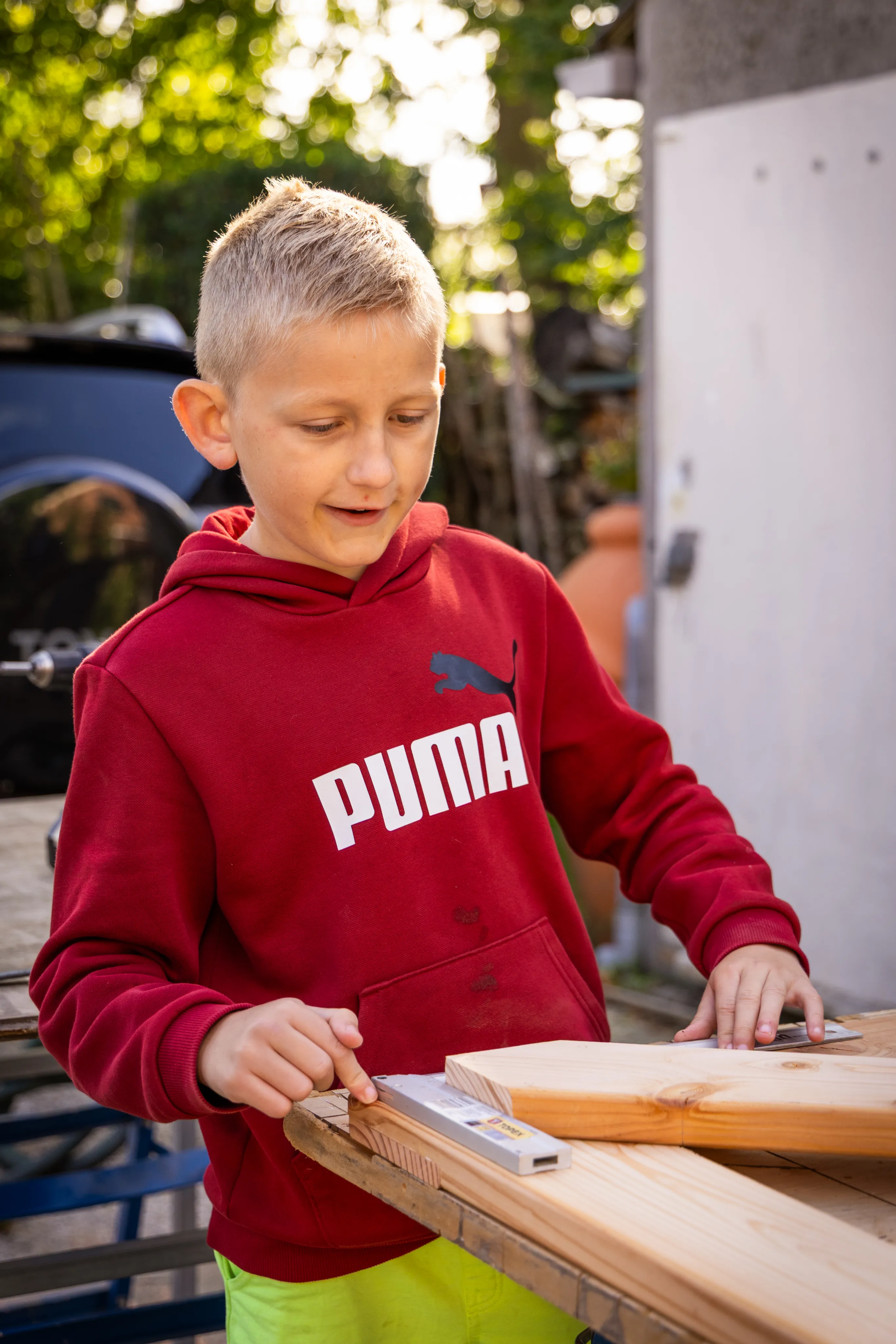 Een jongen die hout aan het afmeten is.